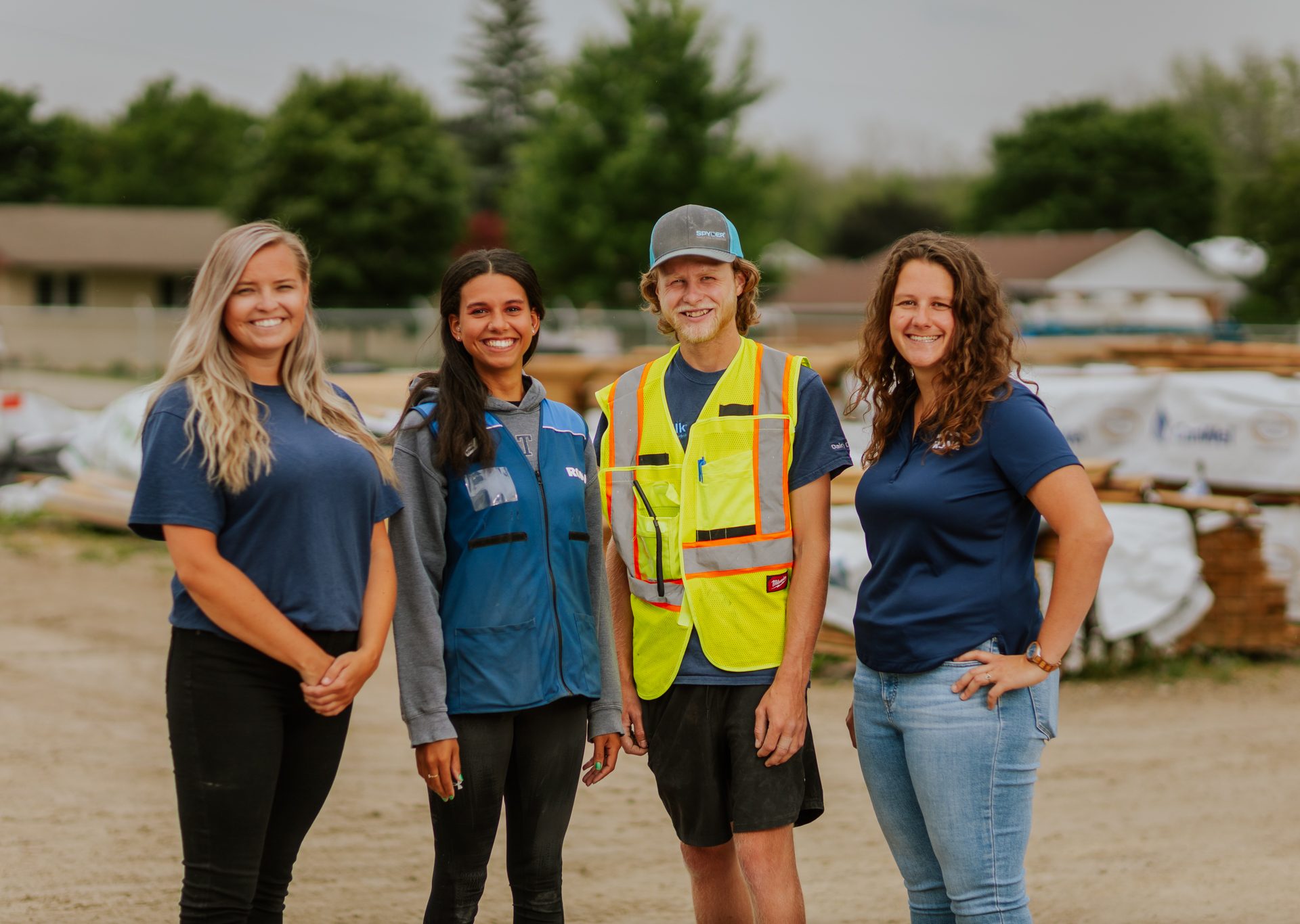 four employees standing in yard